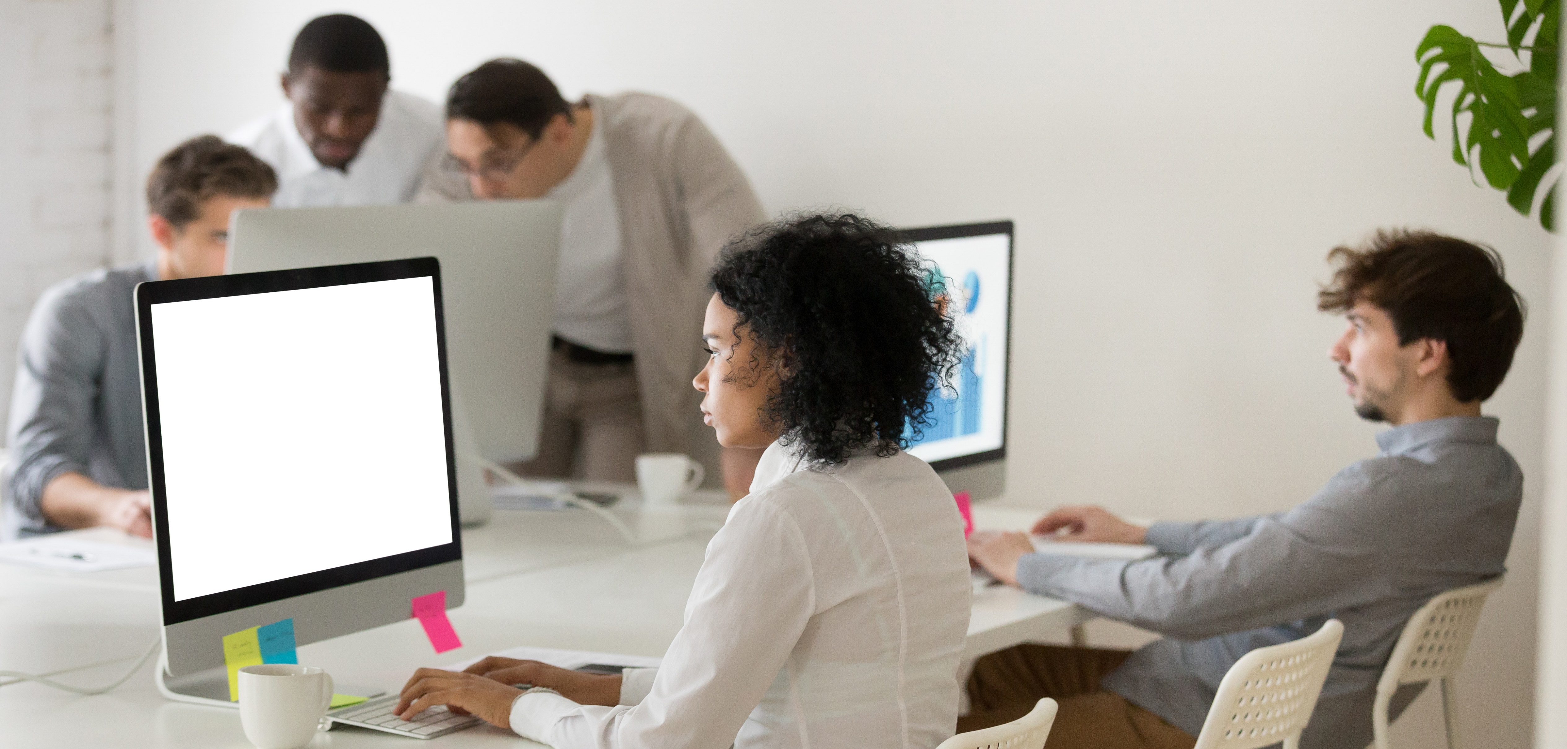 African american woman manager focused on computer work in multi-ethnic corporate office, serious black employee sending email online on desktop in coworking, diverse business people working together