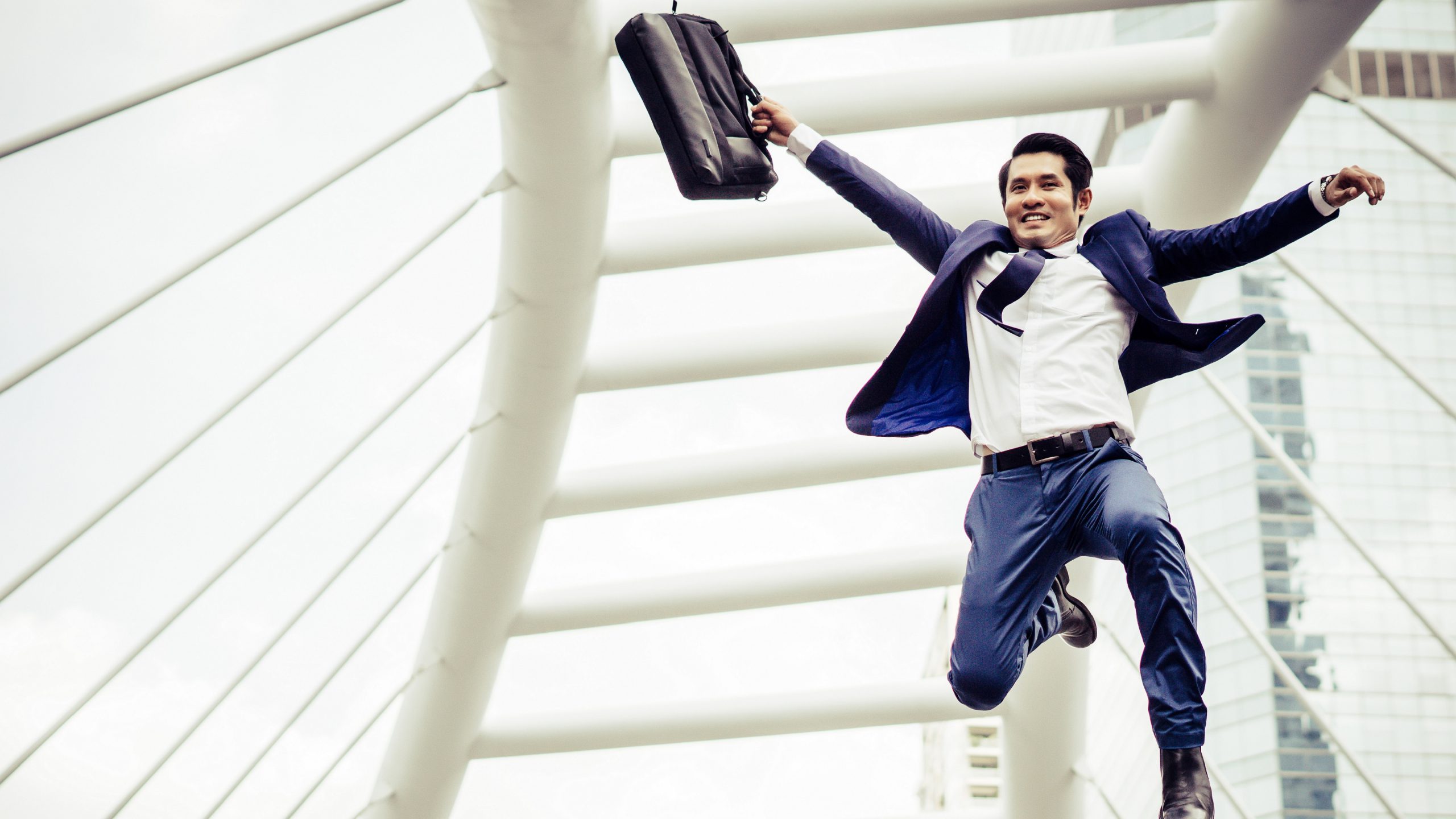 Young businessman with a briefcase running in a city street hurry up to go work.